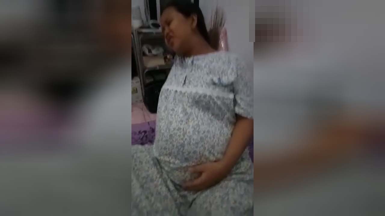 视频:孕妇挺着大肚子坐在床上,一脸疼痛的表情
