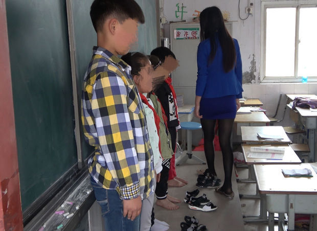 这老师体罚学生,让学生脱鞋罚站,但是后来自已也脱掉鞋子给站在黑板前