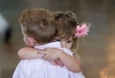 有一张图片,是一个小男孩和小女孩拥抱的,小女孩穿着粉红色的衣服