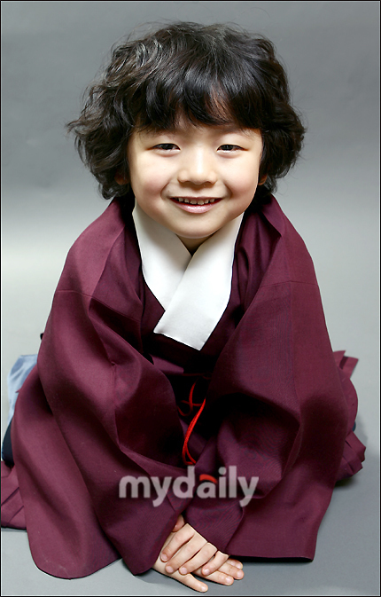 韩国的一个男童星,眼镜不是很大,圆圆的脸.头发有点卷
