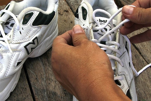 2,解掉鞋带,先用清水将鞋子内外擦一遍,将容易祛掉的污垢霉点先擦拭掉