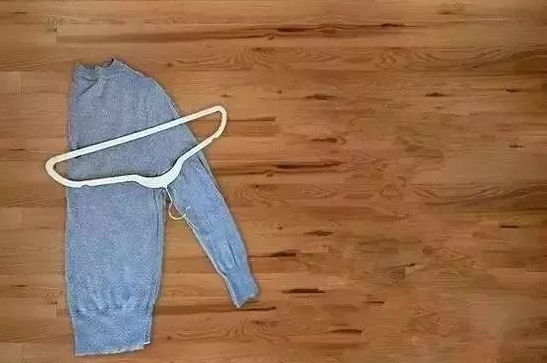 1,羊毛衫充分脱水后,将衣架挂钩处放到咯吱窝位置,斜放到毛衣上面.