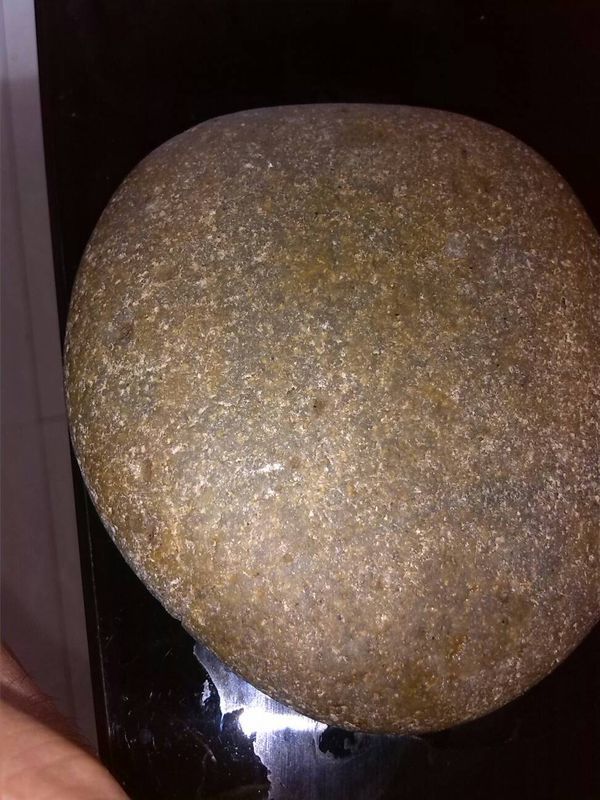 这块石头表面有晶体白色微小颗粒.里面灯光照射成为橘黄色.滴水上去.