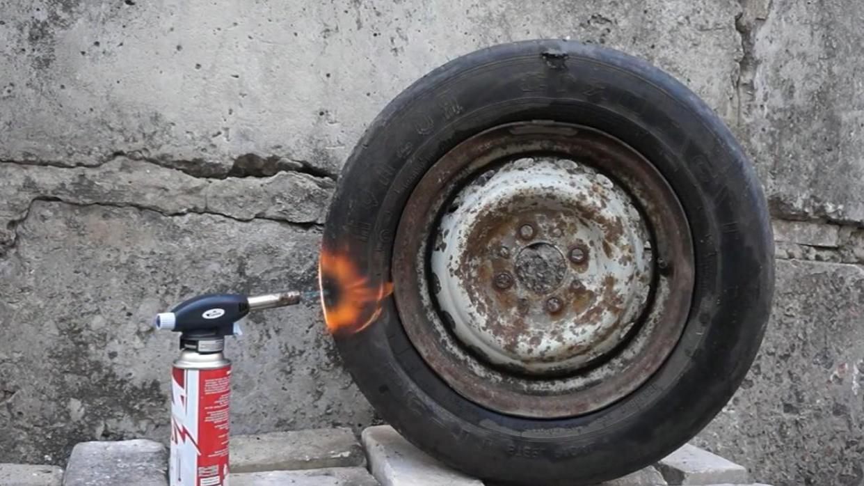 用高温火焰枪烧充气的轮胎
