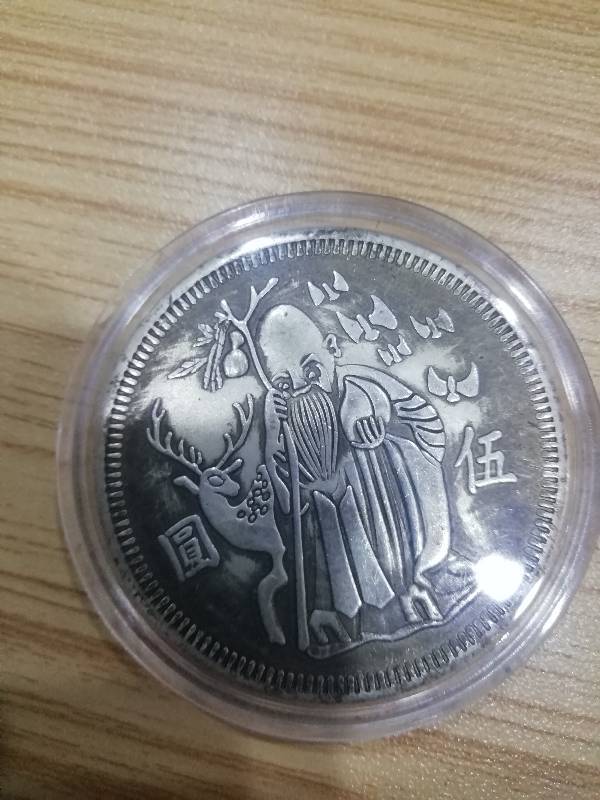 我有一枚五元的银币,正面是寿星公,背面是有个寿字,还有三只鹤,,请问